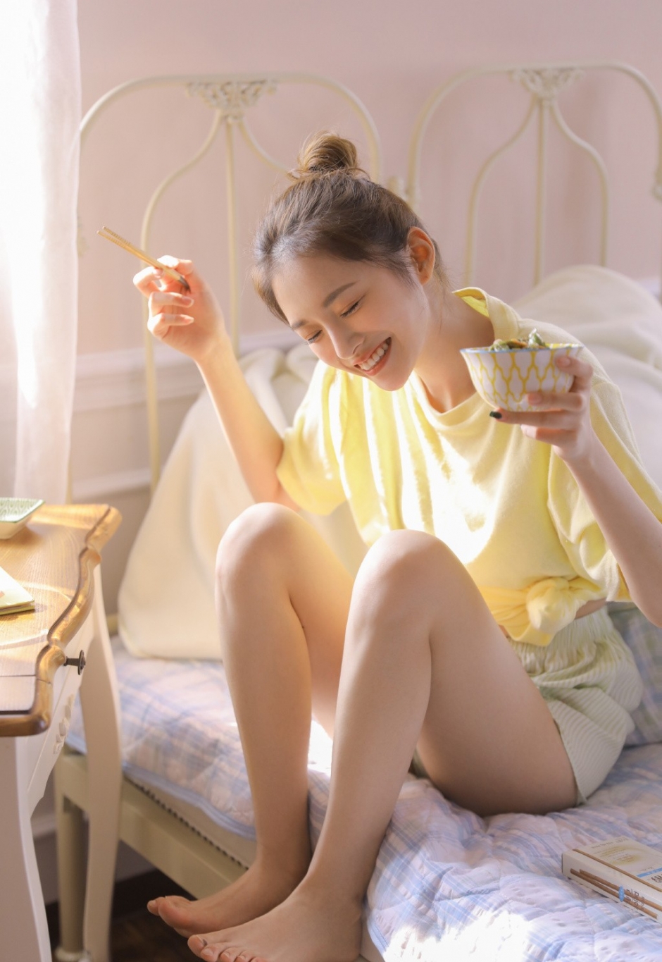 丸子头美女露齿大笑床上诱人长腿图片